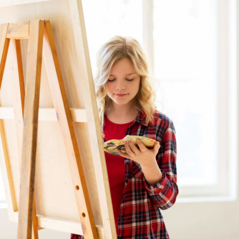 student girl with easel painting at art school PVPQ9UA scaled